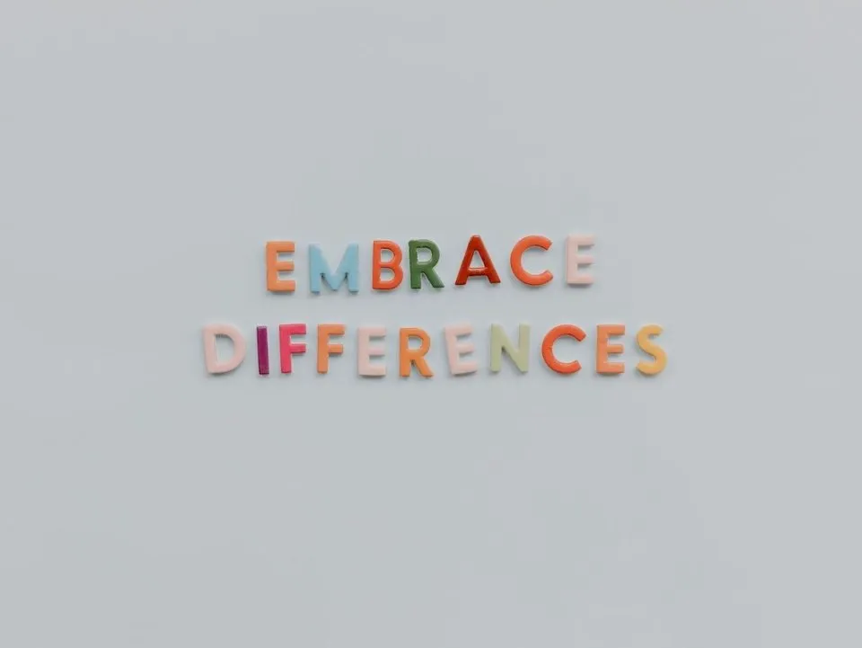 Cut-out letters saying, "Embrace differences" on a white background. (Pexels/Tara Winstead)