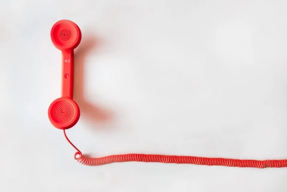 A red telephone on a white background.