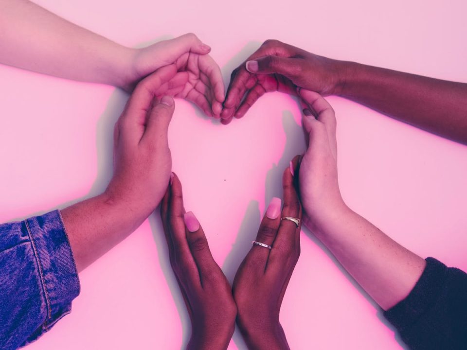 Several people's hands forming a heart shape. 