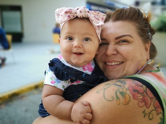 Joni Oldhoff holds her toddler child.