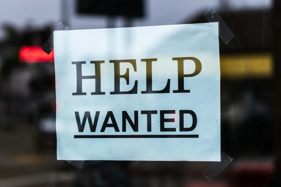 A "help wanted" sign on a window. (Pexels/Tim Mossholder)
