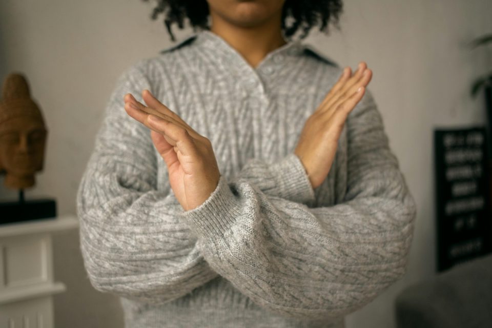 Someone crossing their arms over the front of their body in refusal. (Gabby K/Pexels)