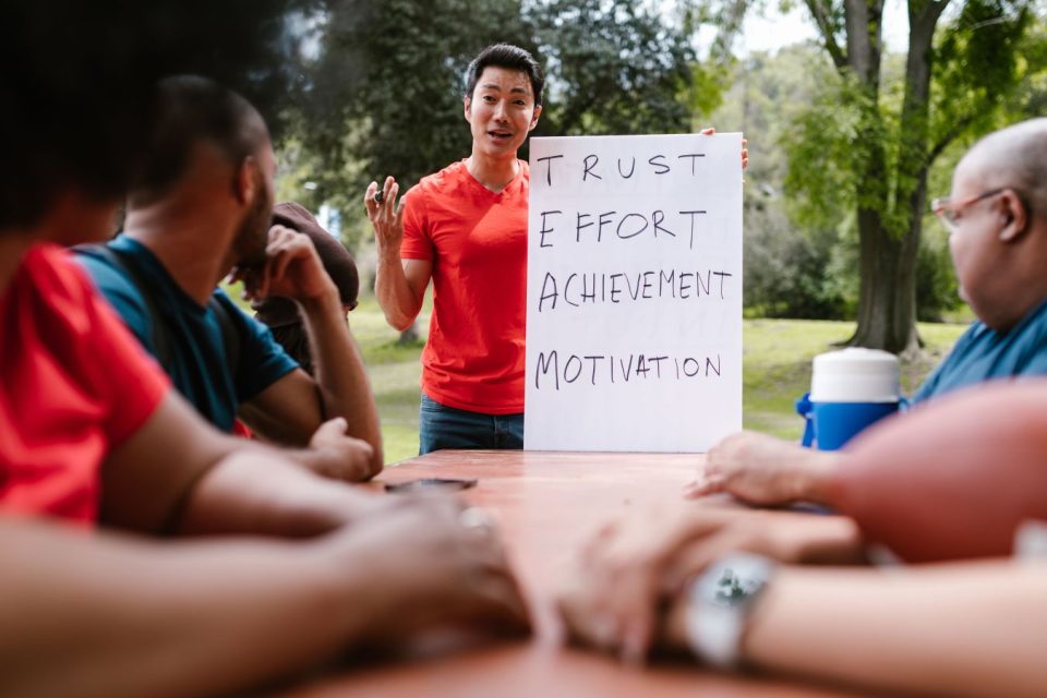 A group of peers participating in a facilitated team-building activity outside. (RDNE Stock Project/Pexels)